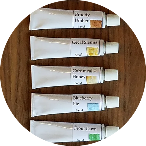 Tubes of finished fowl pigment in a wooden tray.