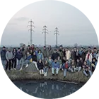 A large group gathered outdoors at dusk.